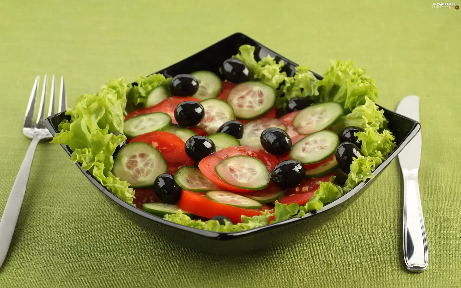 lettuce, cutlery, tomatoes, olives, cucumbers