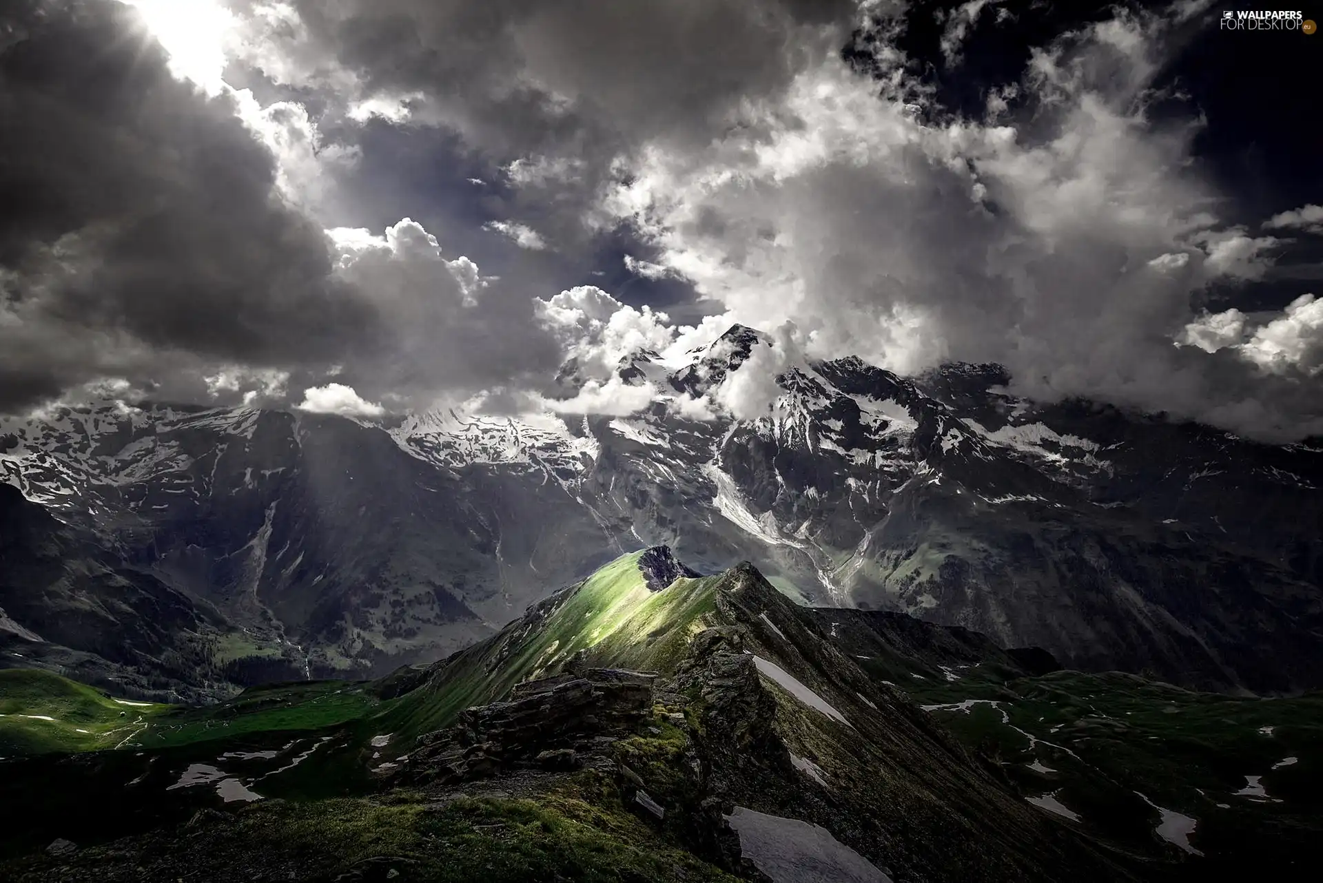 Mountains, clouds, light breaking through sky